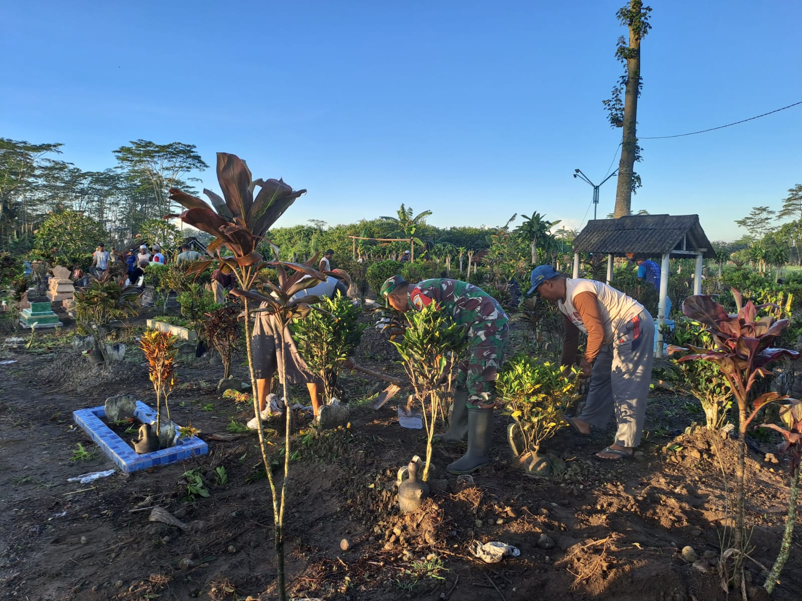 Tingkatkan Kebersamaan Di Wilayah, Babinsa Koramil Talun Gelar Gotong Royong Bersihkan TPU Bersama Warga