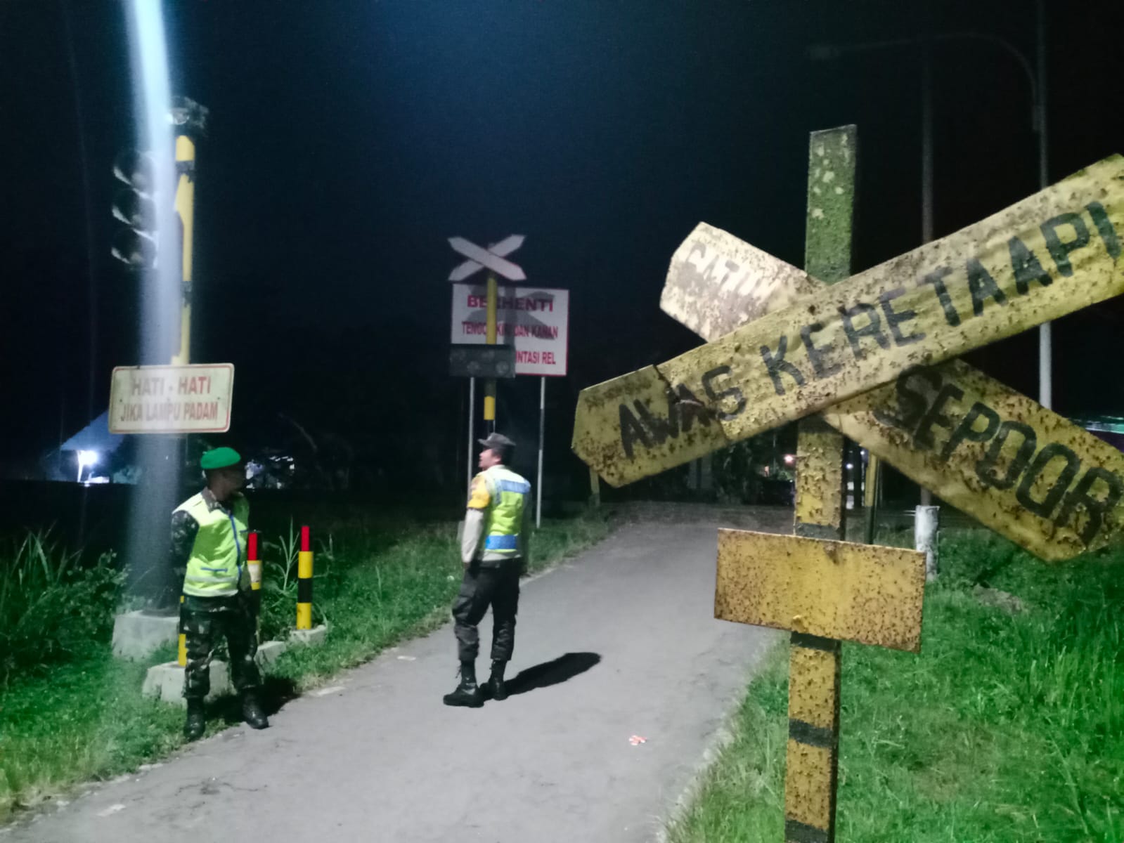 Berikan Rasa Aman, Anggota Koramil Sanankulon Jaga Perlintasan Kereta Api Tanpa Palang